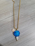 Gold color necklace with blue glass bead charm, pearl, and real seashell