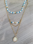 Layered gold color necklace with blue beads and pearl choker
