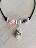 Black suede necklace with wood and plastic beads and sea turtle charm.
