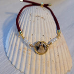 Adjustable cord bracelet with gold color charm